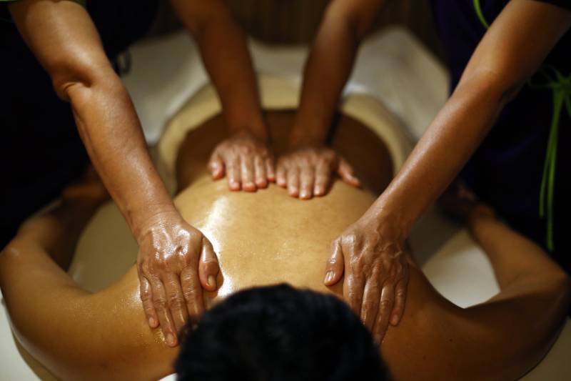Four hands massage therapy in progress